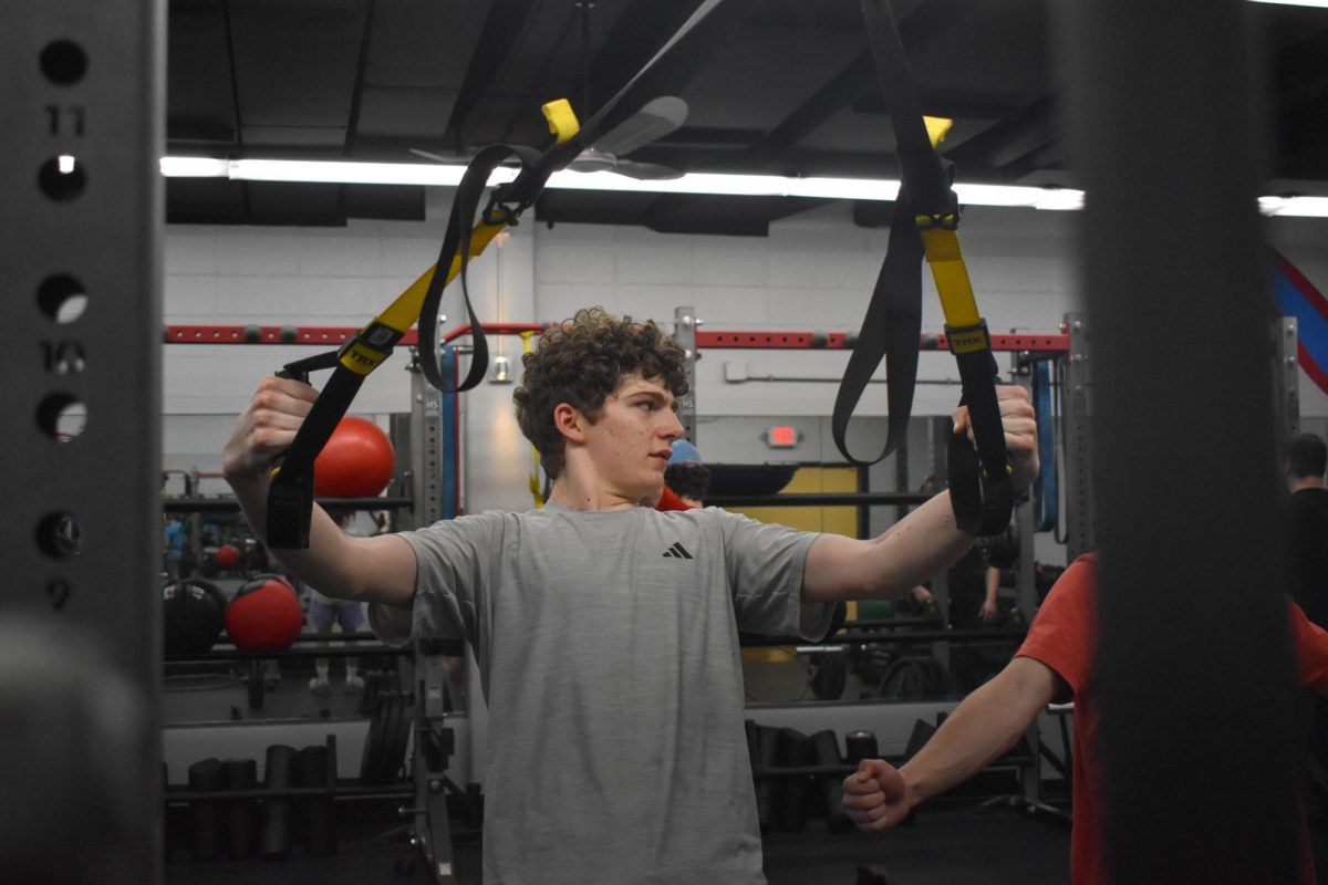 Putting in the work, junior Jannes Pöttker focuses on strengthening his back with TRX bands during Strength and Conditioning class. The class has helped many students like Pöttker enhance their athletic performance outside of school. “Right now I'm doing track and field, [and] I wanted to do sports during the school day and not just after. [Strength and Conditioning] is always [a] nice time with all the guys and I mean, you really get stronger,” Pöttker said.