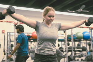 Junior Fiona Dye lifts weights in Strength and Conditioning. Now that the Trump administration has instituted policies such as AI deregulation, tariffs and university funding freezes, women may have to work twice as hard to get half as far. "[Trump] wants America to be more divided; he wants to inspire hatred in people,” feminist club member and junior Clara Lazarini said.