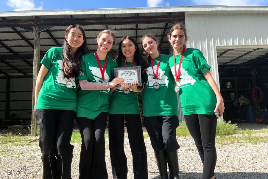 Smiling at the Missouri Envirothon state competition, the Parkway West and Parkway South Envirothon team holds their award plaque. The team placed second in the state level after completing a written test and a presentation for the competition, which covered the subject of forestry. “I'm proud of the team for placing second at state. It's not an easy competition, and everyone has worked so hard this year,” sophomore Malia McLellan said.