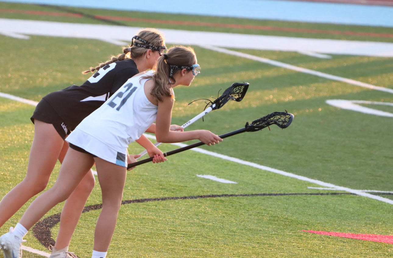 Junior Annie Deckelbaum stands ready to attack the ball alongside a defender. Deckelbaum has been a part of the varsity girls lacrosse team for two seasons. “Lacrosse is awesome because it allows me to meet new people and have fun,” Deckelbaum said.
