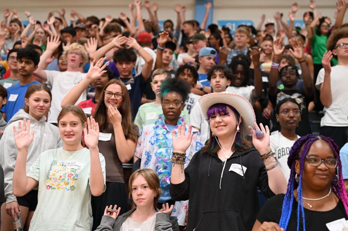 Raising her hands in the air, freshman Jillian Sternhagen follows Mr. Mooney’s lead during an activity Aug. 15 at freshman orientation. Surrounded by other freshmen, Sternhagen learned an “A O E day” chant to help remember their new weekly high school schedule. Students participated in several activities to get to know each other, the school and the upperclassmen. “We got to tour the school and learn where everything in our schedule is. The energy [at orientation] was fun; the leaders were peppy and got us excited,” Sternhagen said.