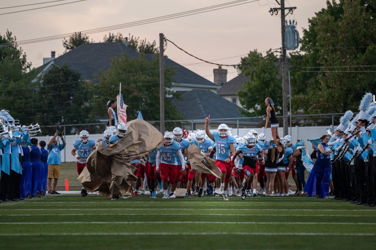 Breaking through the pre-game Homecoming banner alongside his team, senior Mason Freund, wearing number 15, runs ahead across the field. Freund stepped into the role as one of the quarterbacks for the game against McCluer North on Sept. 12. “I needed to be the leader, and I wanted to be the leader in this situation. It all has to work together to win. You can’t just have one good player to win. You’ve got to have all 11 pieces work together,” Freund said.