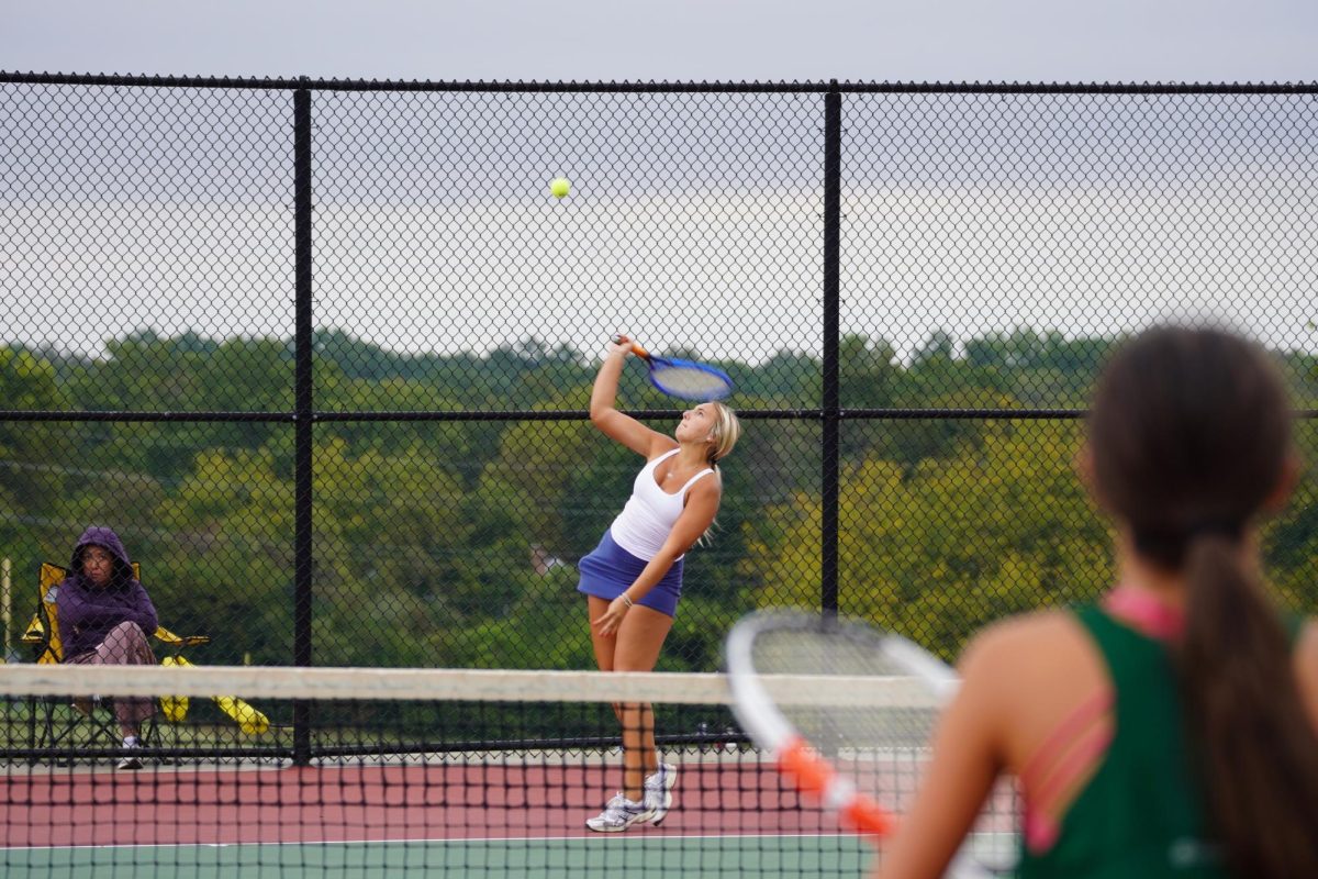 Wind blowing through the tennis court, sophomore Maddie Mills serves, tying the score against Marquette at 5-5 on Oct. 8. Playing with a new partner, junior Bree Lang, the duo kept their game strong despite the harsh wind. “We [worked] well together; [Bree] is good at the net, and I’m good at my groundstrokes,” Mills said.