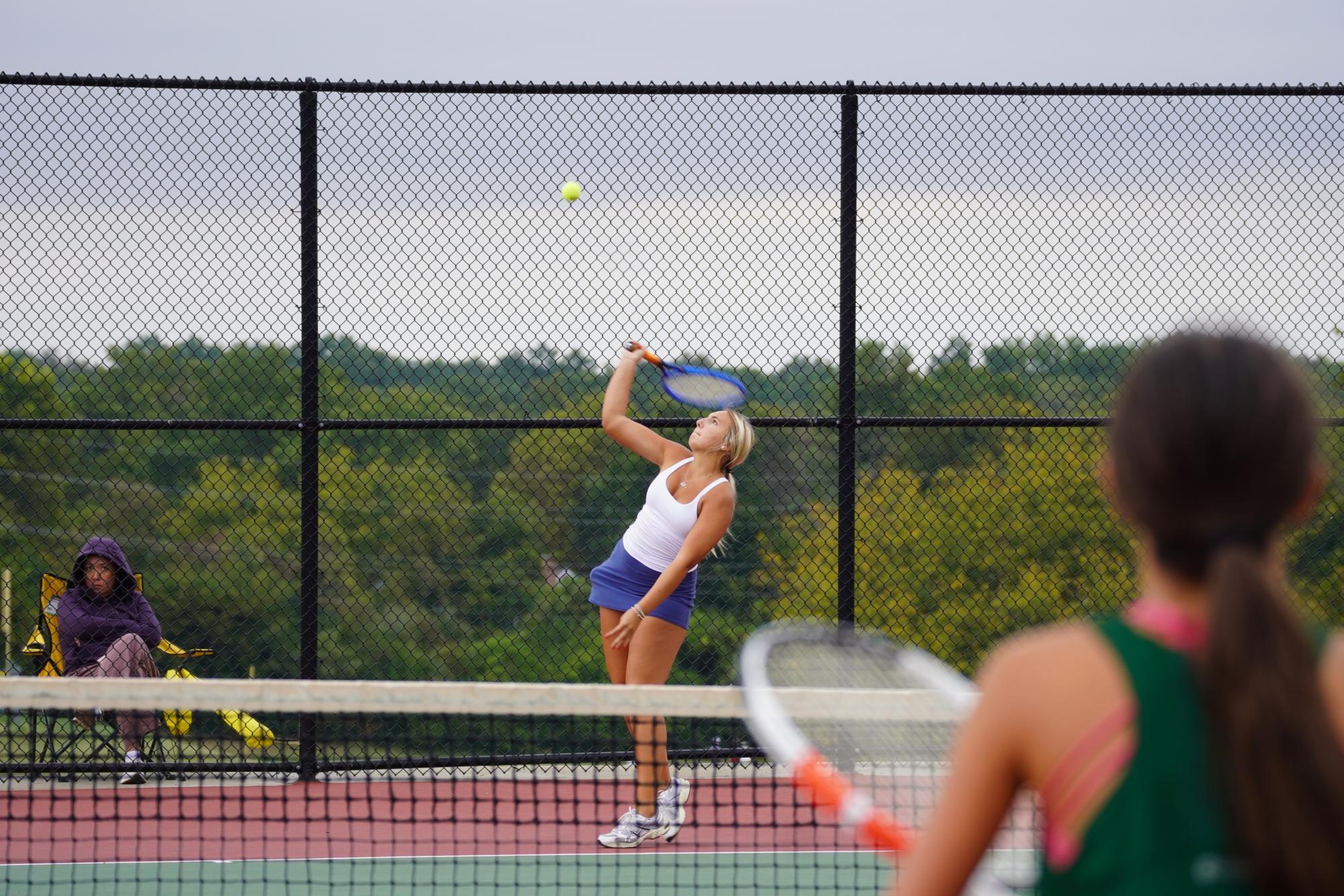 Wind blowing through the tennis court, sophomore Maddie Mills serves, tying the score against Marquette at 5-5 on Oct. 8. Playing with a new partner, junior Bree Lang, the duo kept their game strong despite the harsh wind. “We [worked] well together; [Bree] is good at the net, and I’m good at my groundstrokes,” Mills said.