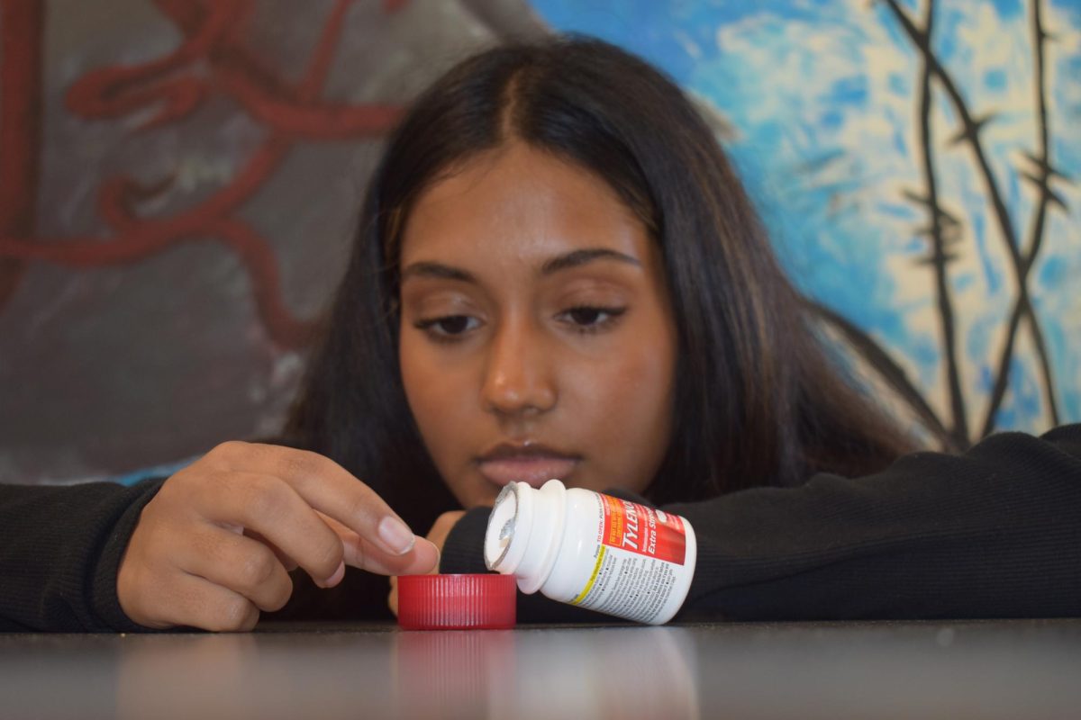 Senior Dhiya Prasanna examines a bottle of Tylenol. Prasanna has observed data in science labs and in real life. “[I] advise the public not to just look or search for information that supports your argument, but search for information that doesn't support it,” Prasanna said. 