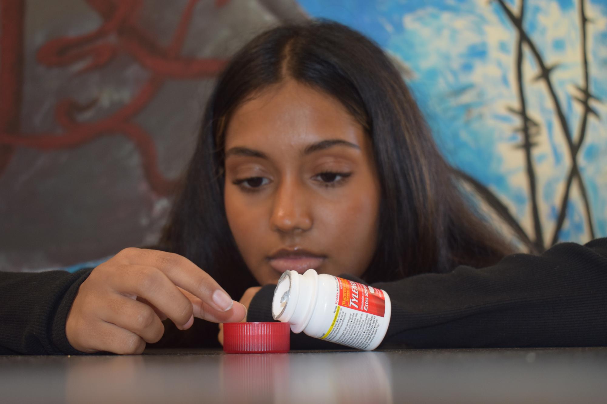 Senior Dhiya Prasanna examines a bottle of Tylenol. Prasanna has observed data in science labs and in real life. “[I] advise the public not to just look or search for information that supports your argument, but search for information that doesn't support it,” Prasanna said. 