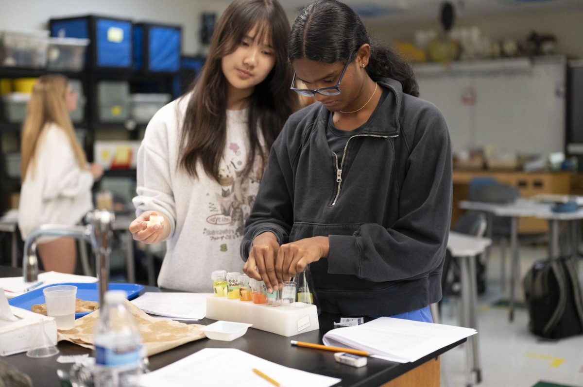 Taping over a tube filled with sucrose, sophomore Shree Nidhi Sikkal Kumar and her group mate, junior Bethany Liao test the osmosis of a potato. Sikkal Kumar took AP Biology this year after taking both Honors Biology and Honors Chemistry as a freshman and loving the classes. “I want to major in biomedical science and work in a medical lab (in the future),” Sikkal Kumar said.
