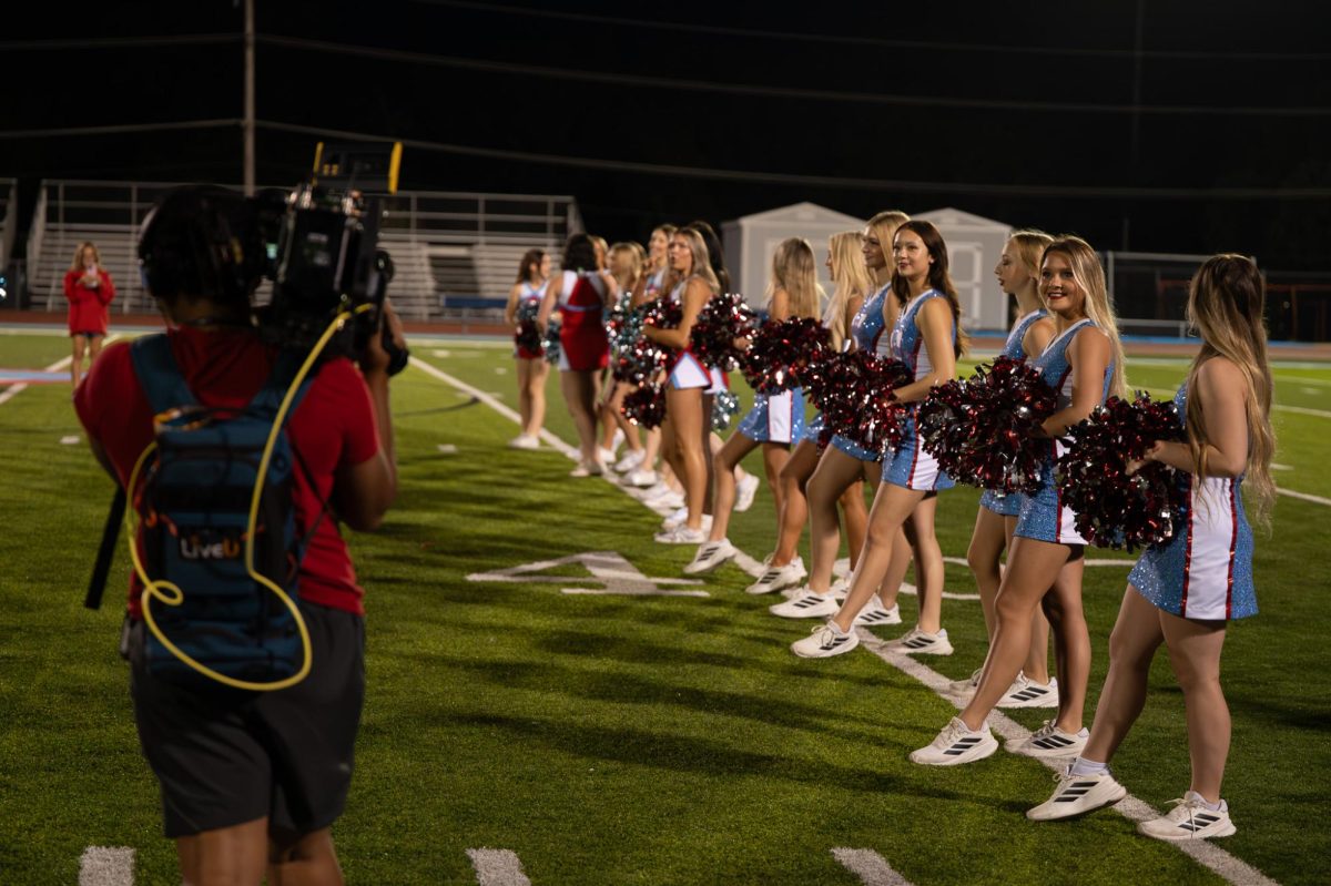 Sophomore Izzy Macapanpan lines up with her Longhorn Line teammates to prepare for the camera on the football field. Macapanpan and the team were invited to perform at the pep rally. “I’ve been on the high school dance team since freshman year, but I’ve been dancing since I was three years old,” Macapanpan said. “All the girls are really nice, and we’ve all become really close this year. [Being on TV] was a big thing because the dance team had never really been featured on the news like we were today.”