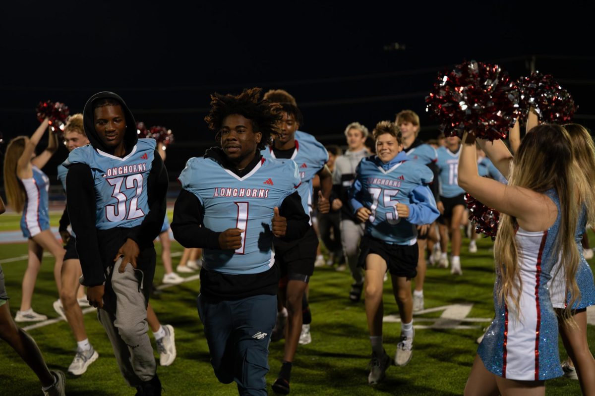 Jersey on and energy up alongside teammates, senior Dashawn Horskins runs through a line of cheerleaders and Longhorn Line dancers across the football field at 6:30 a.m. Horskins wore his jersey to get in the spirit for the upcoming home football game against Lindbergh. “[It was] cool to be there early [in the] morning [and] see classmates,” Horskins said. “I tried to tell my team to get everybody [to] get louder.”