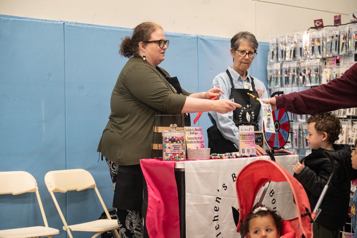 Helping a customer, print room assistant Gretchen Williams operates her booth at the West High Craft Fair from Oct. 25-26. This was Williams’ first time participating in the Craft Fair with her new craft shop, Gs Beaded Boutique. “People have always said, over the years, ‘you should open something.’ [I replied that] I would rather just make [my crafts as] gifts for people. I just started [the online store] up, and it's been okay. I'm always surprised [by] how many views I get and [the] people from different states buying things; somebody from Alaska bought something the other day.”
