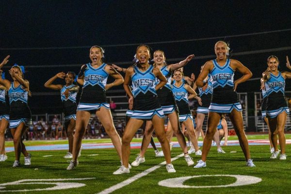Standing tall, stacked in a precise formation, the cheer team strikes a signature pose during halftime on Sept. 12 at the varsity football game. Nearly a month after this performance, the cheer team performed at the Missouri Cheerleading Coaches Association (MCCA) regional competition on Oct. 4, 2025. “We've all come [to] work together a lot more,” sophomore Elyssa Philippi said. “We're a lot closer than we were [earlier in the season] and going to state has made us closer [in] trying to work with each other, learn [new] skills and make our team better.” 