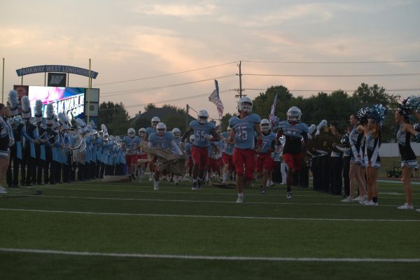 Senior Easton Kimbrough rips through a sign to help lead his team on the field for the Homecoming football game on Sept. 12. The Longhorns played McCluer North High School. “We do a chant every time before we run through the poster,” Kimbrough said. “It gets us hyped up and ready for the game, especially when we get to run out in front of the crowd.”