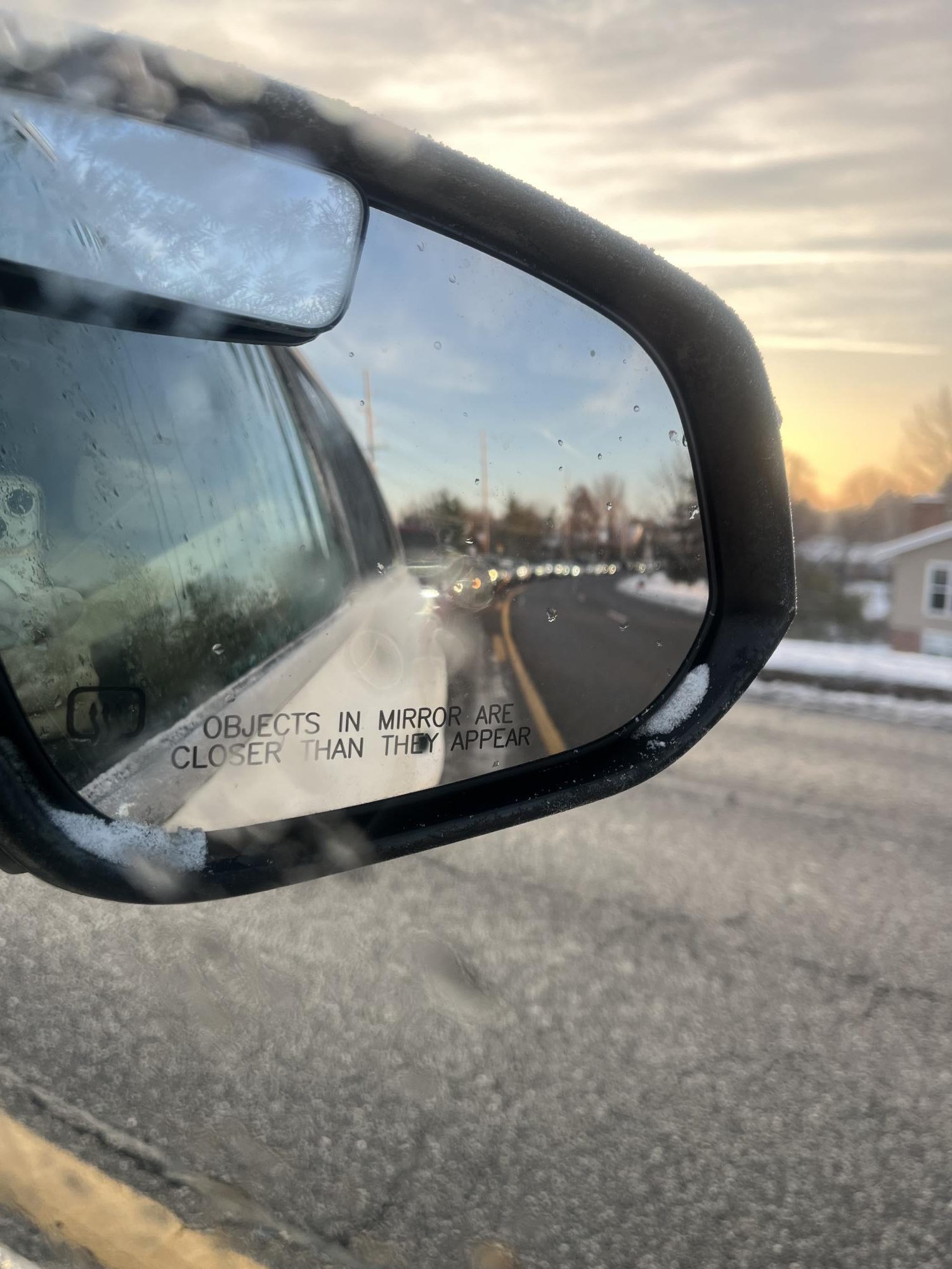 Traveling on a recently-plowed road, a car sits in the morning line along with hundreds of others waiting to enter school in the morning. With the snow day yesterday, frosted-over windshields and patches of ice meant many students struggled to make it to school on time.