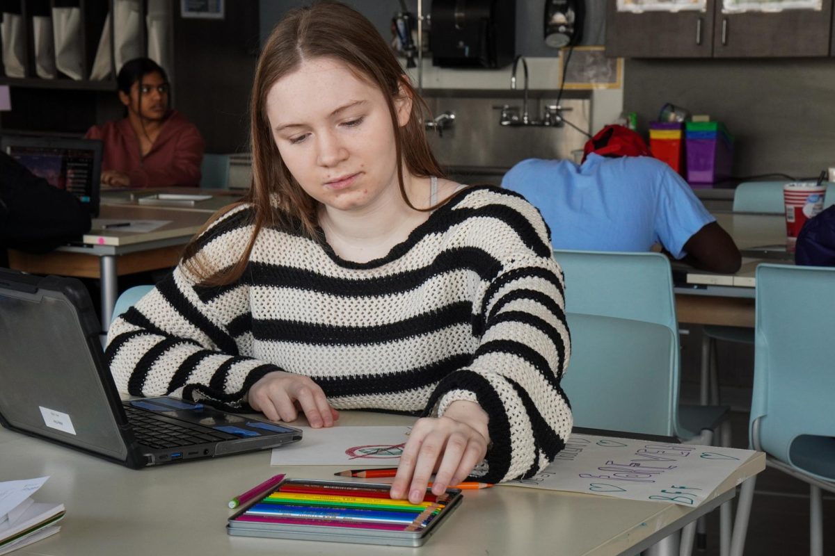 Reaching for a new color, junior Abby Tice works on her art in drawing club during AcLab. On Jan. 9, Tice was encouraged by her friends to attend her second meeting. “I’m not very much of an artist, but I get to see my friends in Drawing Club, and they support me. My favorite part is meeting new people, and I’m [glad] I’ve found an environment like this,” Tice said.
