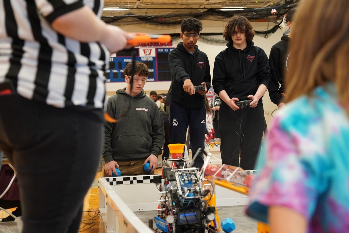 Helping to direct their driver, junior Alex Hermann, sophomore Vinay Sebastian helps his team collect as many VEX Blocks as possible and place them into goals across the field. This year’s game, “Push Back,” is extremely fast-paced, requiring strong cooperation between team members. “I’m new to robotics, but it has taught me so many different roles and how to work efficiently and effectively in a group,” Sebastian said. 
