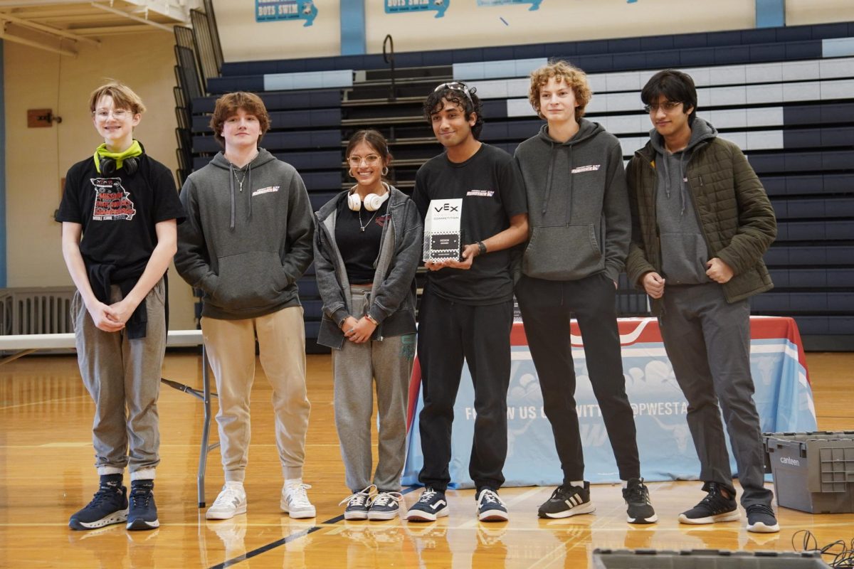 Displaying their plaque to the crowd, team Blue Brains poses with the Design Award, which they won based on their outstanding team interview and engineering process notebook. While all robots are made out of VEX metal, they are allowed to have a limited number of custom plastic parts, which Blue Brains took full advantage of. “We've been pretty creative with using parts in abnormal ways and pushing the limits of some materials. Robotics is a very collaborative activity, so this is very much us accomplishing something together. In particular, I'm really proud of how the members we've taken on this year are starting to come into their own during the judges' interview,” senior Anish Jindal said. 