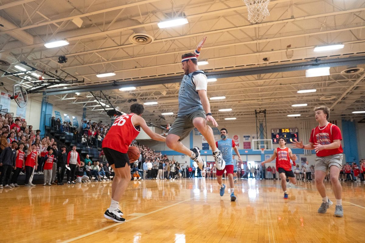 Defending his opposition — the senior team — history teacher Ryan Newton jumps high to block an incoming shot. Newton’s involvement in West athletics encouraged him to play in the Senior vs. Faculty basketball game. “I just wanted to go play basketball and compete. [Playing] with the other teachers against the seniors was just a fun opportunity. [It was great] with 1200 people in the gym, a good environment and a back-and-forth game,” Newton said.