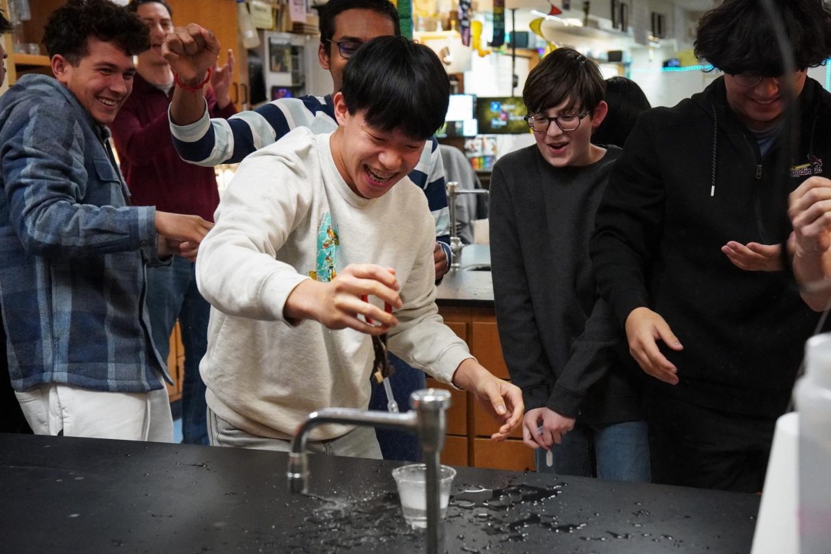 Surrounded by fellow scientists, sophomore Samuel Huang smiles from the explosion of dry ice on Feb. 11. After helping each other hold onto the pliers and pipette tightly, the group was able learn about the phases of an element through a hands-on experiment. “We were all helping each other out during this experiment, and being able to have fun really helped us learn. Getting to experience things [I’ve] never done before [was special]. [Mr. Anderson], our teacher, had to go out of his way to get supplies for this, and I really appreciate all of the opportunities we’re given,” Huang said. 