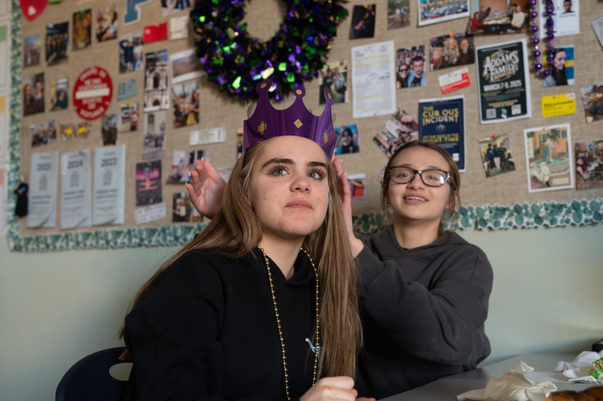 Getting crowned by a classmate, freshman Gianna Fisher celebrates finding the king cake baby to celebrate Mardi Gras Day in French. Only one person in the class could find the baby, and it was an honor she was happy to receive.  “We didn't know [where the baby was], but I found it, so I was the queen of the class. Next to me [was] Alana, and she was the one who put the baby in the cake. She helped me fix my crown,” Fisher said.
