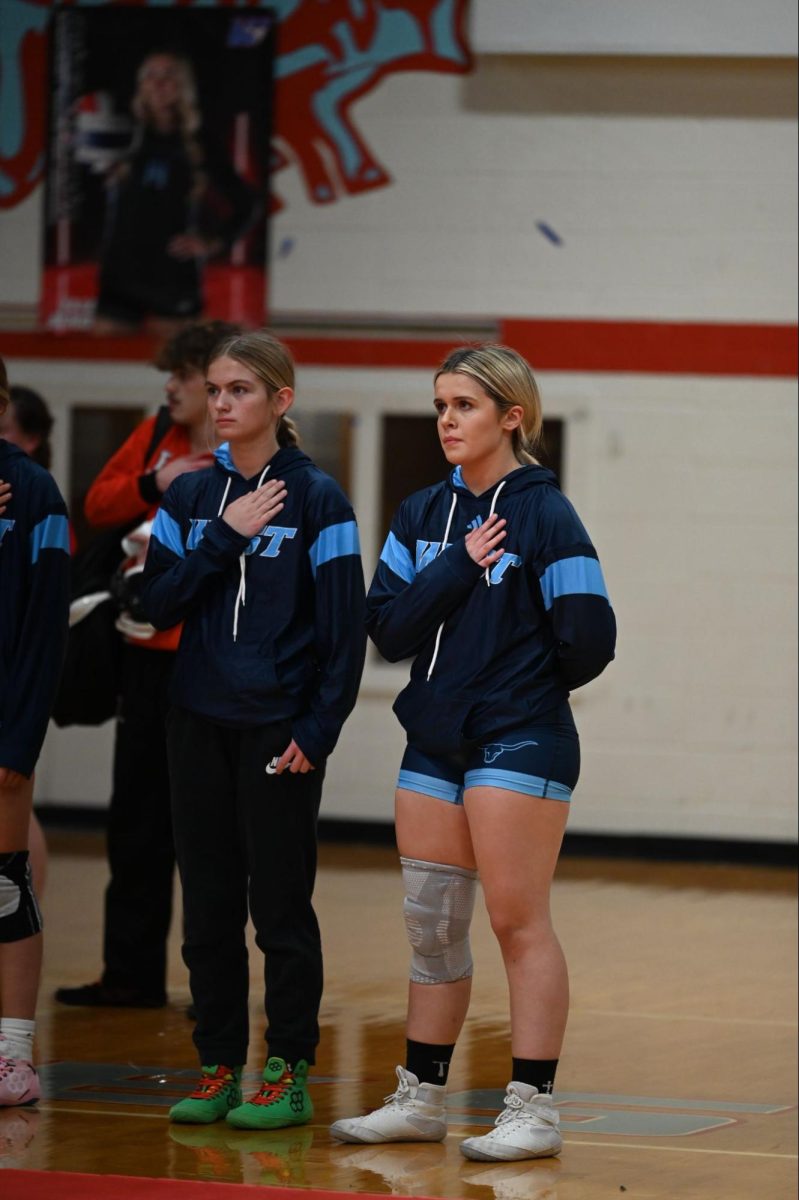 Standing with their hands over their hearts while the national anthem rings out, girls’ wrestling team captains and juniors, Jaeda McRaven and Delaney Wehrmeister, line up together at the start of the meet. Entering the season, both captains have maintained focus on leading the team through the pressure and uncertainty that come with competition. “It can be stressful putting in so much effort and not knowing how things will turn out, but seeing people around you work hard and improve makes it worth it. It pushes me to keep going and help the team when they need it,” Wehrmeister said.
