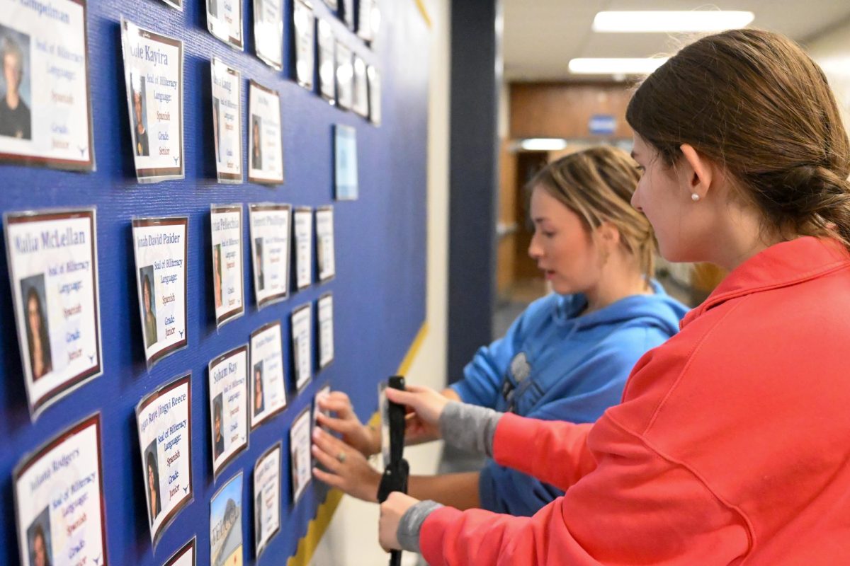 Seniors Charlotte Putnam and Leilani Domijan set up the Seal of Biliteracy recipient board in the main hallway. Last year, Putnam and Domijan both earned their Seal of Biliteracy in Spanish. “Earning the Seal of Biliteracy shows your determination and your willingness to move forward even when it’s hard. My advice is practice often, remember that practice makes perfect and [know] there [are] always opportunities to improve,” Domijan said.