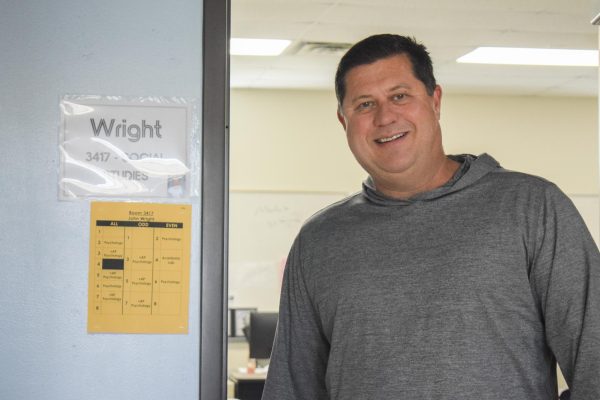 Social studies teacher John Wright stands outside his classroom door, smiling as he prepares for the school day. Teaching has long been part of his life’s path. “I enjoy getting to know kids and working with kids,” Wright said.
