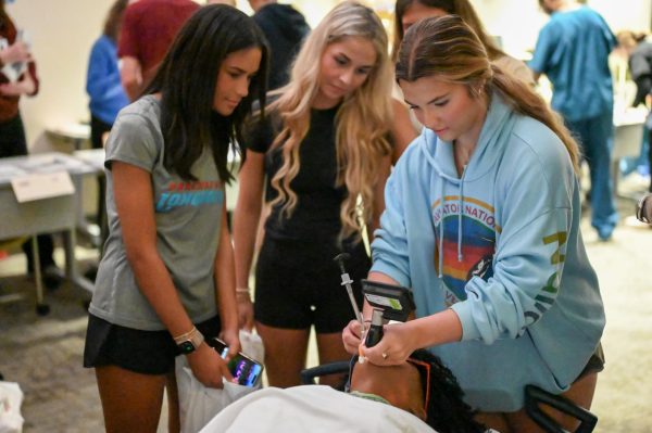 Opening the medical manikin’s mouth, sophomore Layne Nations performs an intubation. This was one of several activities offered on a field trip to Mercy South, where students were able to connect with many healthcare professionals. “The field trip was super fun, and I was able to learn a lot about different health care paths,” Nations said.